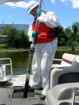 Collecting sediment samples with a push core sampler.