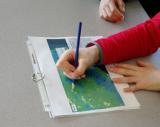 Child points at EnviroAtlas map, watershed lesson