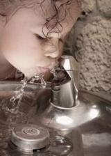 child drinking from fountain