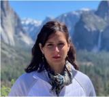 picure of a woman standing in front of mountains