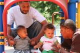 Children and their dads play at the playground