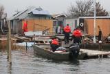 Flood response crew walks toward damaged homes after coastal storm