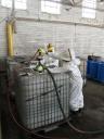 Contractors empty chemical totes into new bulk shipping containers.